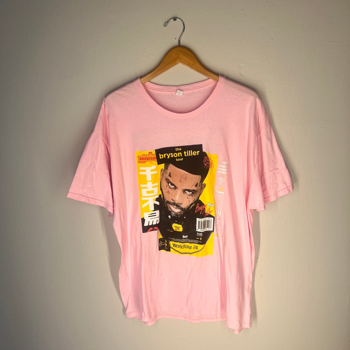 Front view of pink Bryson Tiller World Tour 24 graphic T‑shirt on hanger