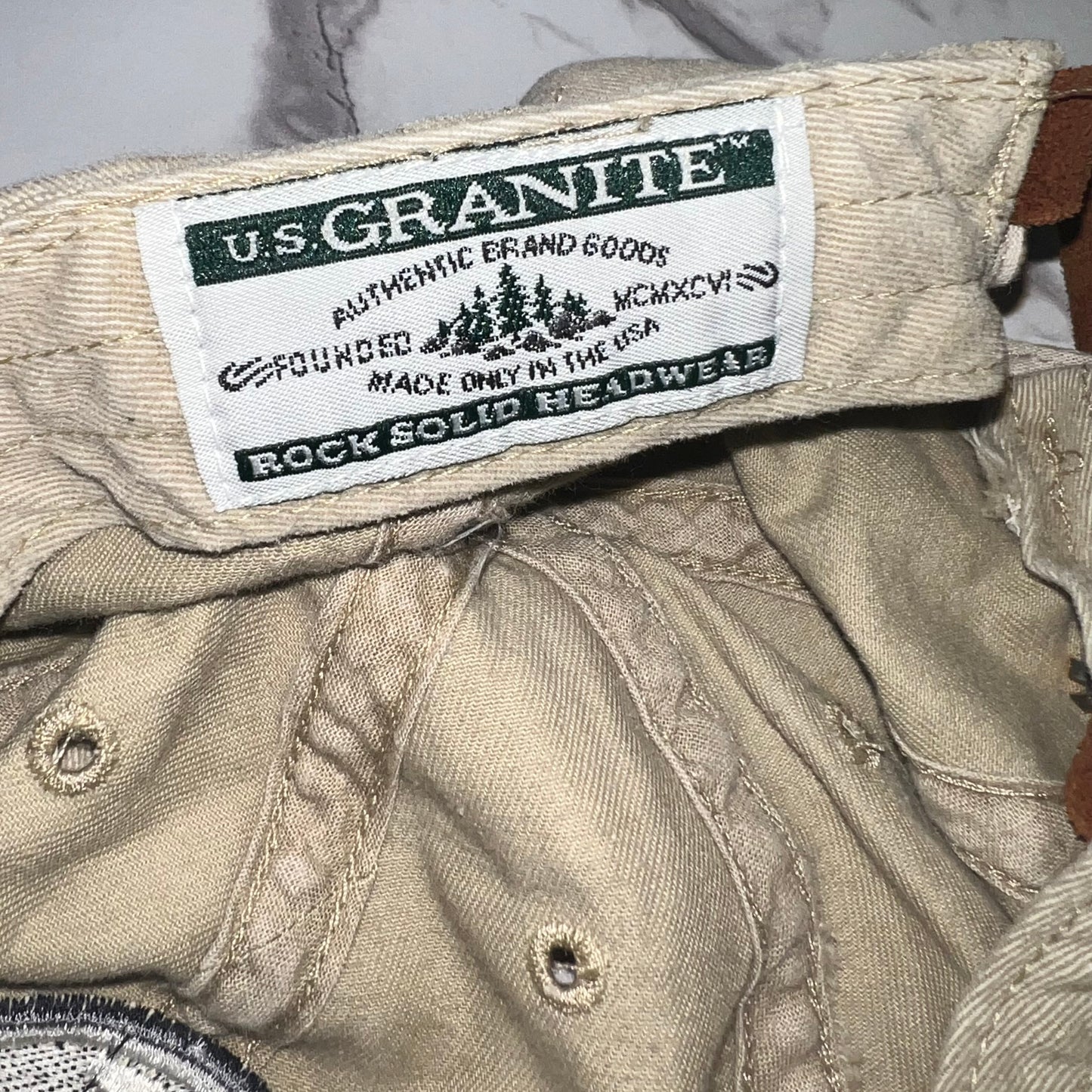 Close-up of U.S. Granite “Rock Solid Headwear” woven tag inside band
