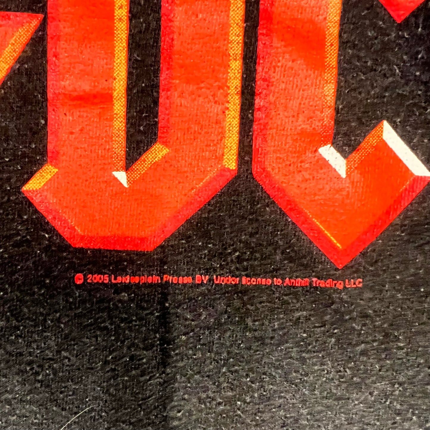 Zoomed-in detail showing 2005 licensing print below AC/DC graphic