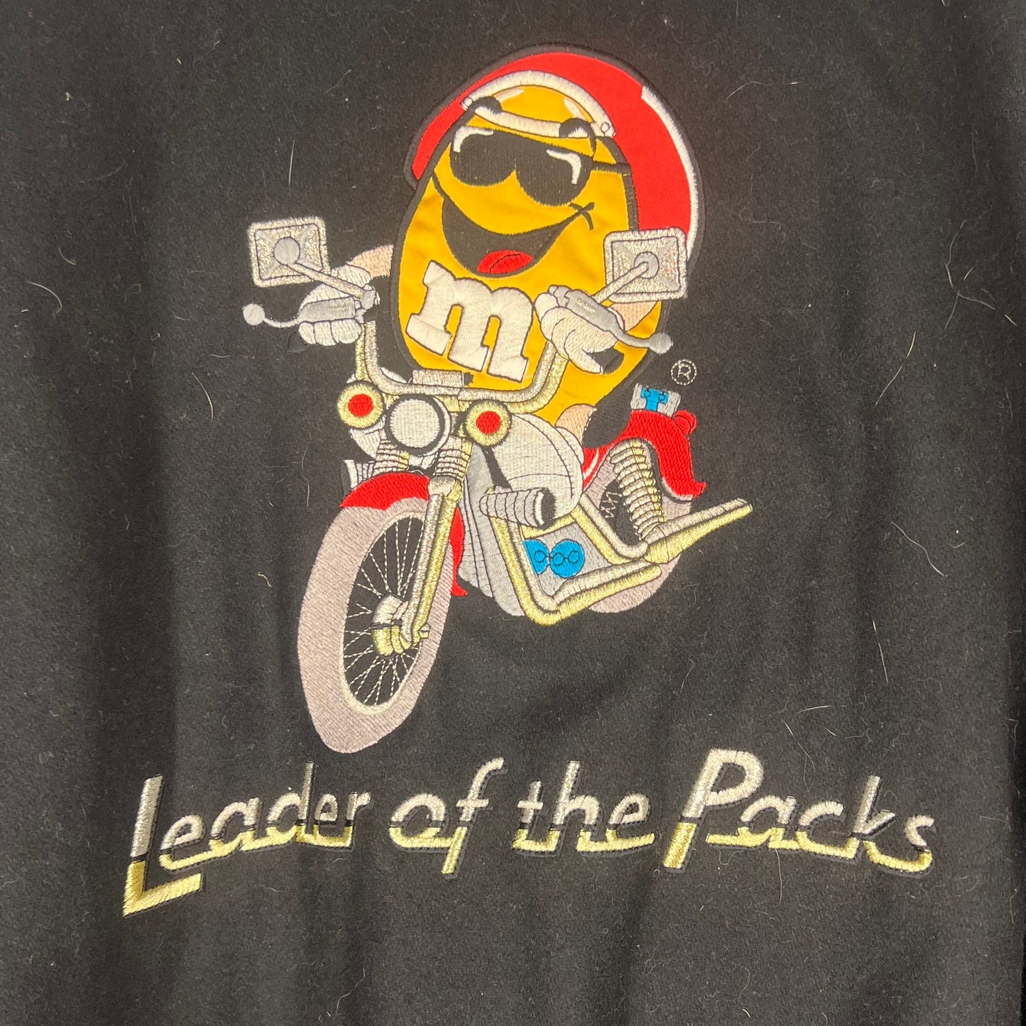 Close-up of large Yellow M&M motorcycle embroidery with “Leader of the Packs” text