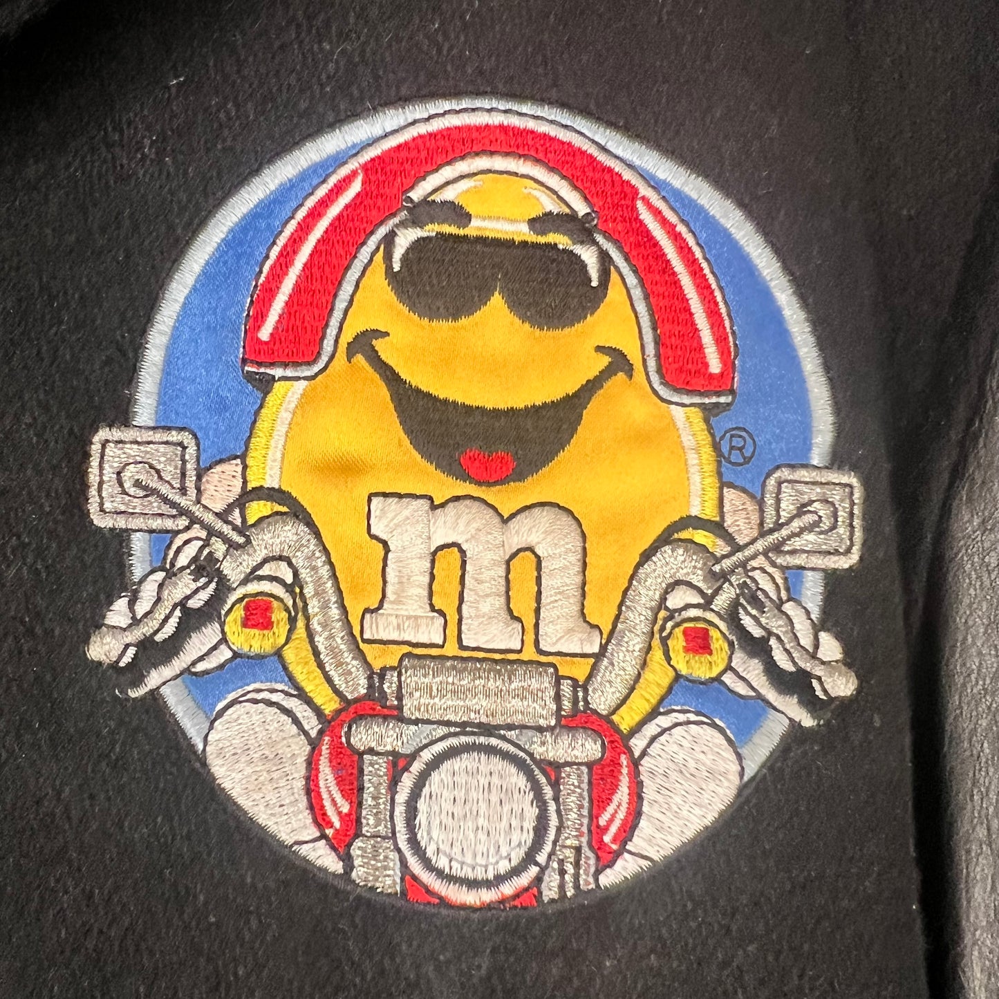 Close-up of Yellow M&M motorcycle embroidery on front chest