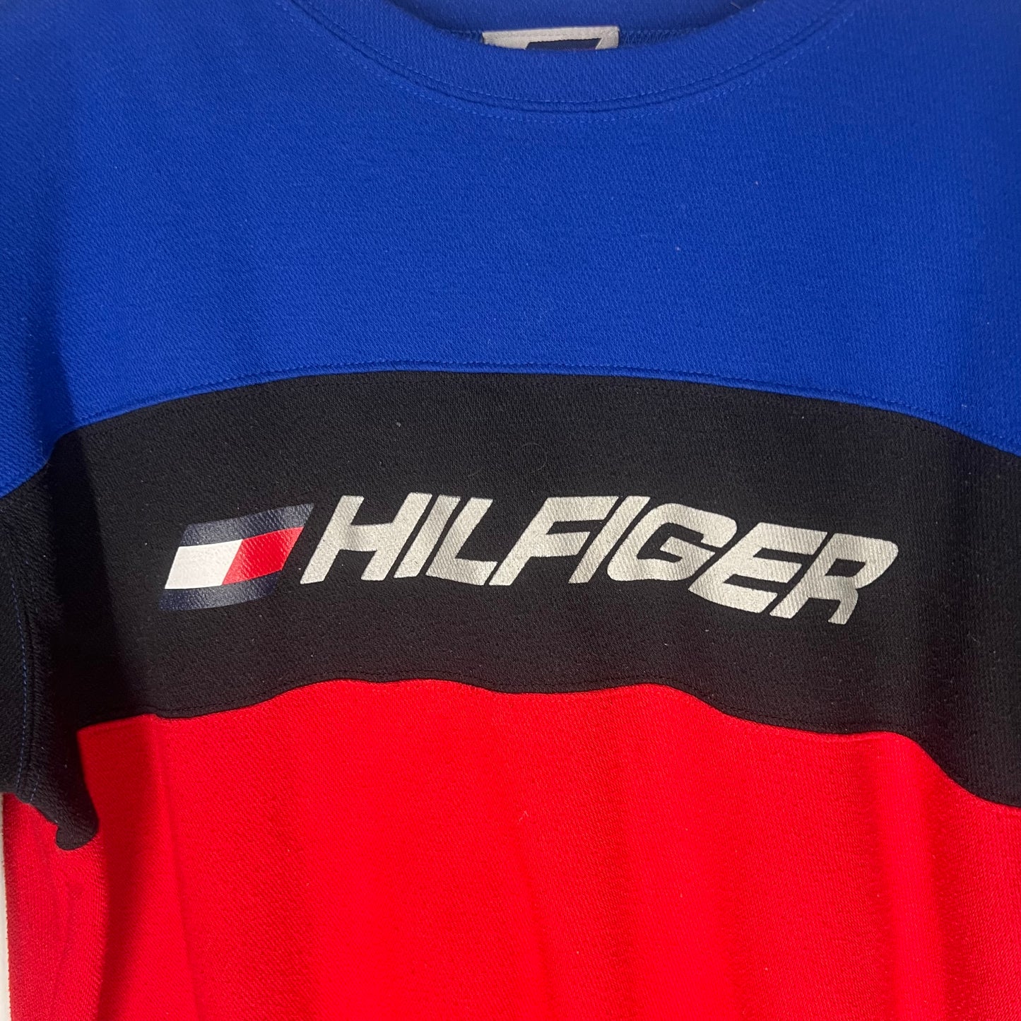 Close-up of embroidered Hilfiger logo with flag on vintage colorblock tee