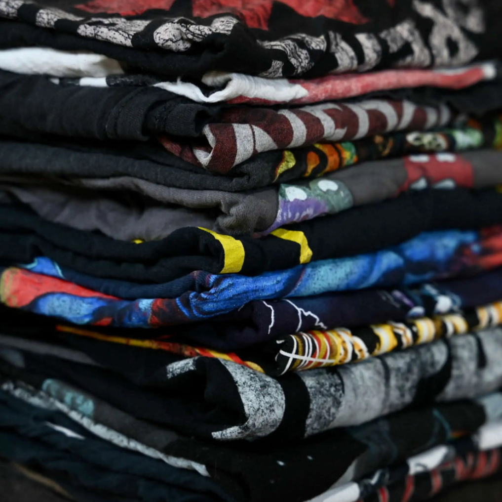 Stack of assorted vintage-style graphic t-shirts for 2-pack mystery bundle. Designs vary and may include reprints or retro-inspired graphics.