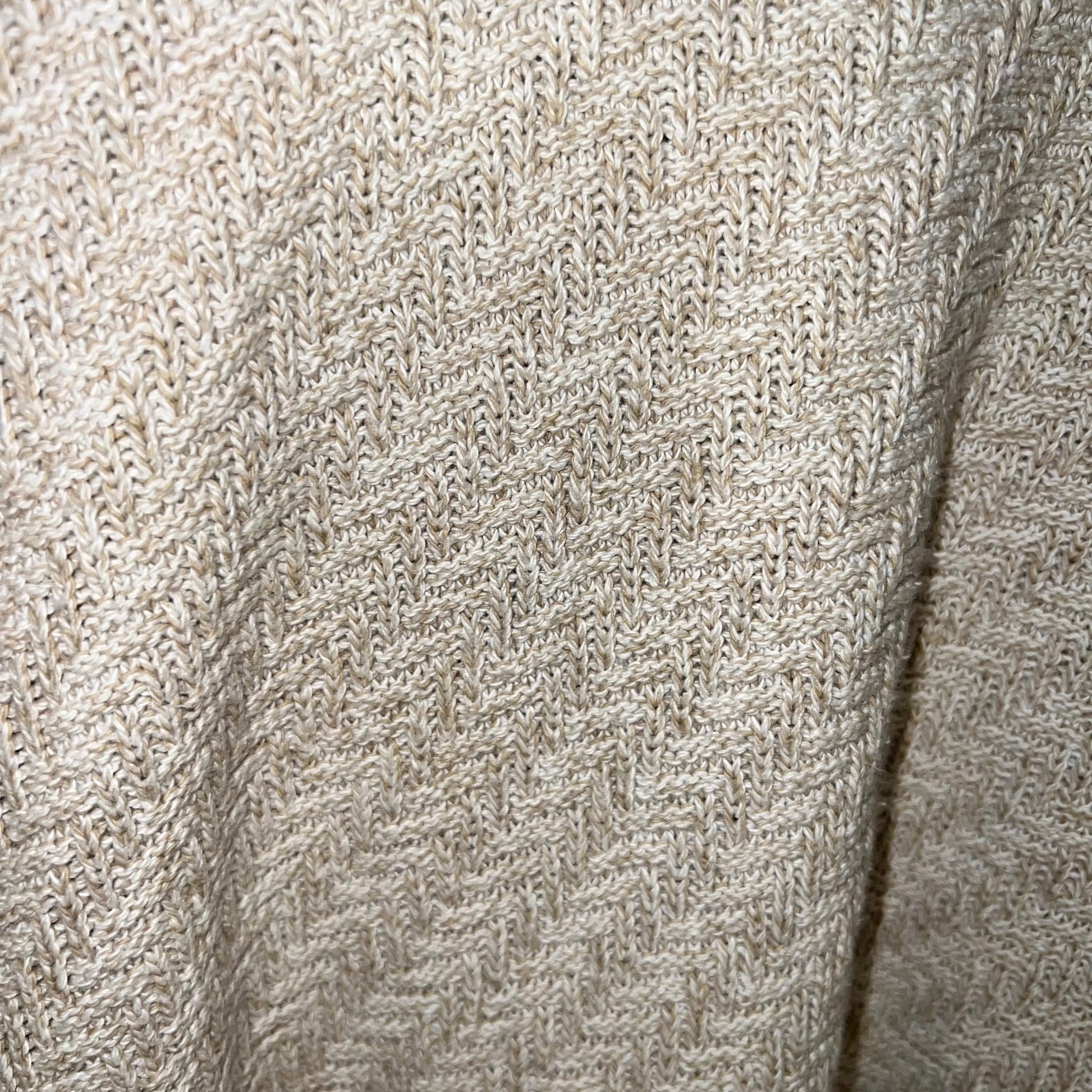lose-up of herringbone knit pattern texture in oatmeal/tan yarn