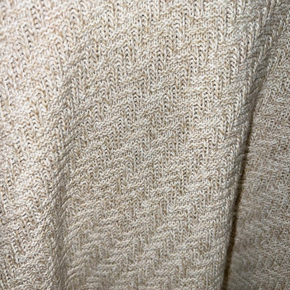 lose-up of herringbone knit pattern texture in oatmeal/tan yarn