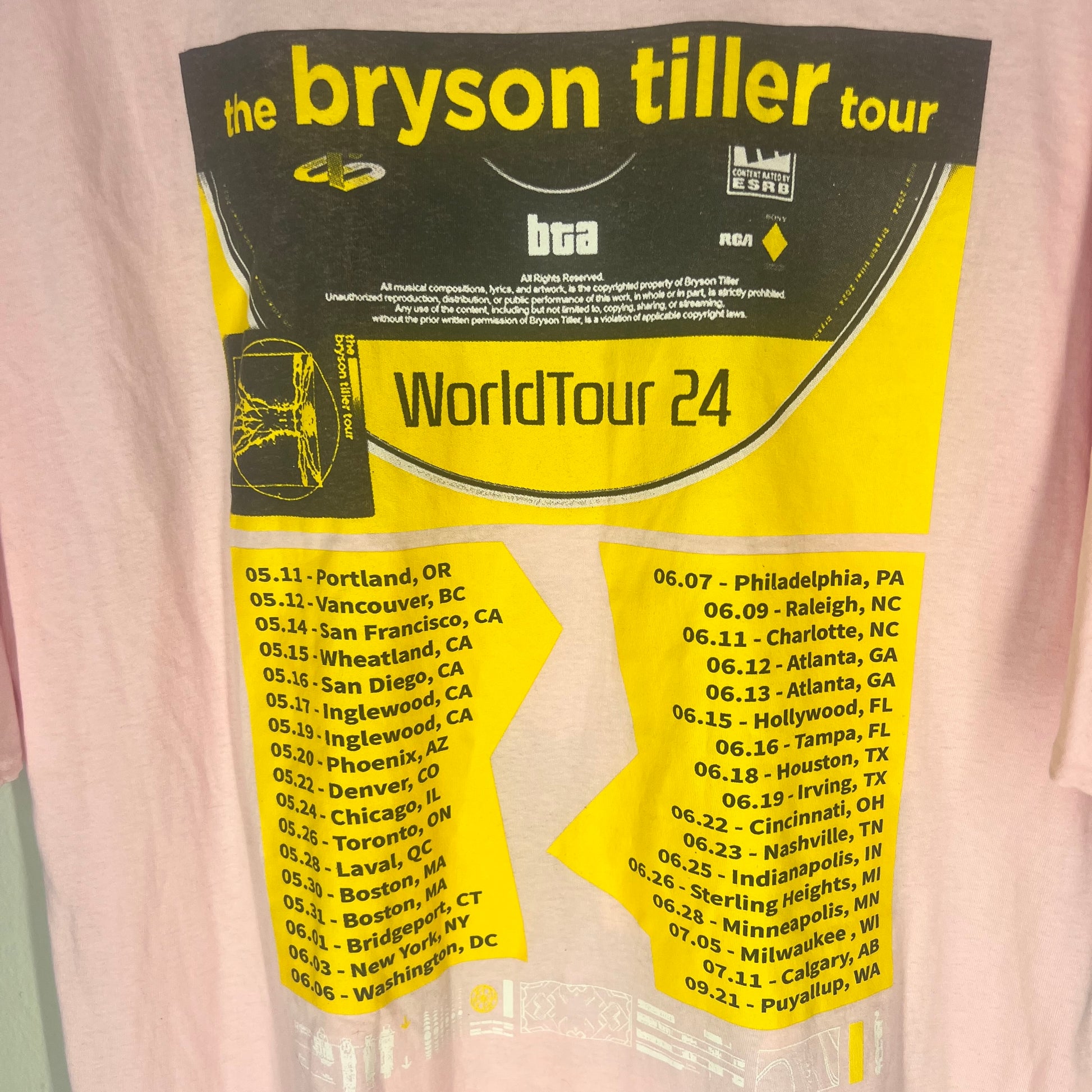 Close‑up of back print showing World Tour 24 design and city list