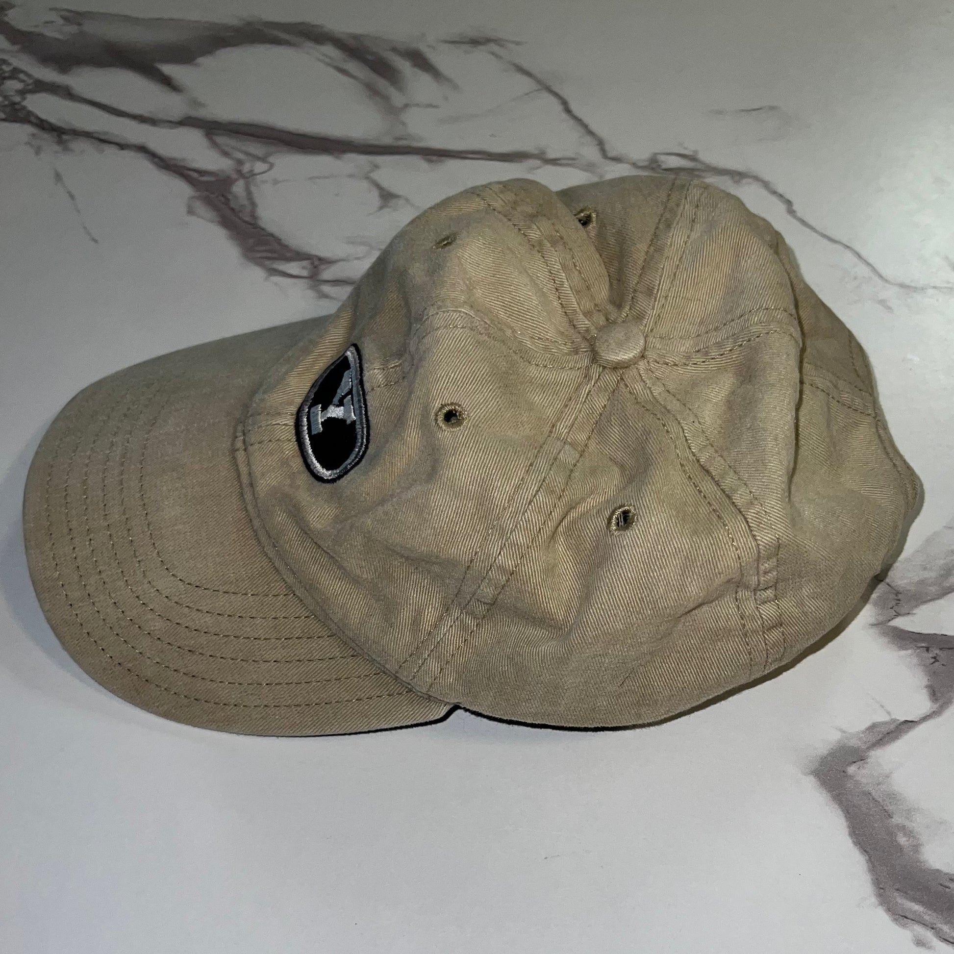 Side view showing faded khaki fabric and crown construction