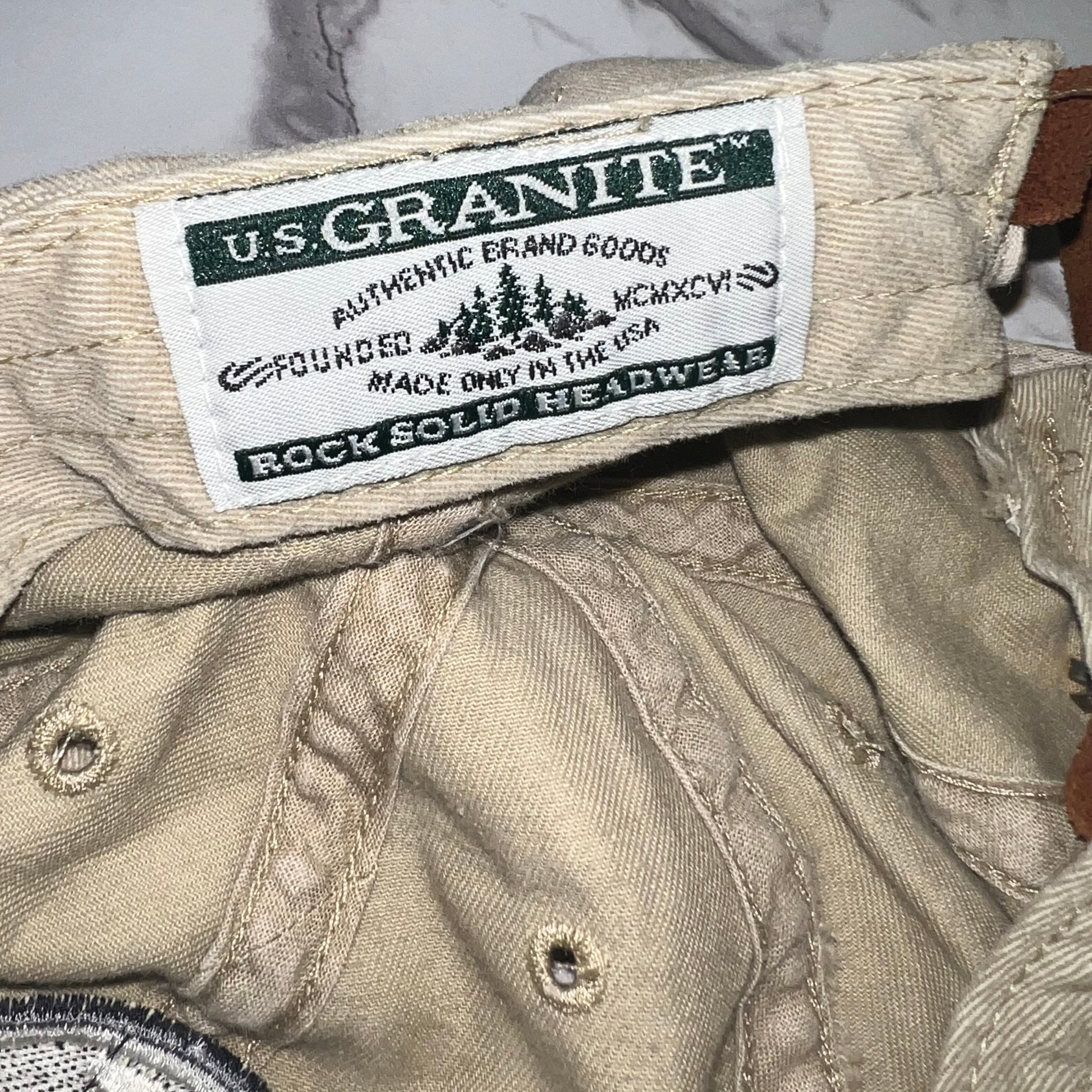 Close-up of U.S. Granite “Rock Solid Headwear” woven tag inside band