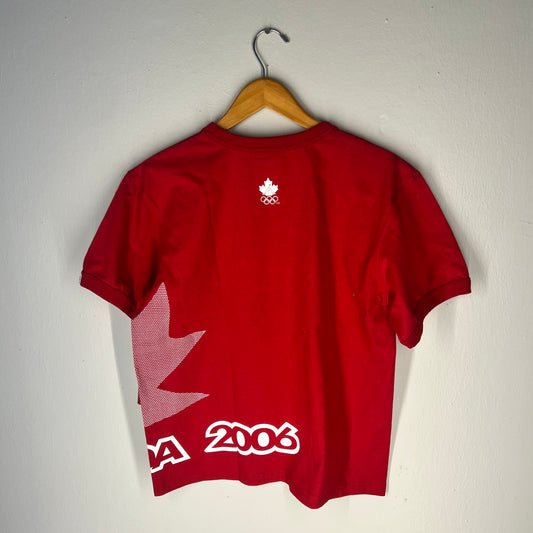 Back view of tee with maple leaf wrap graphic, “2006” print, and Olympic logo under neckline.