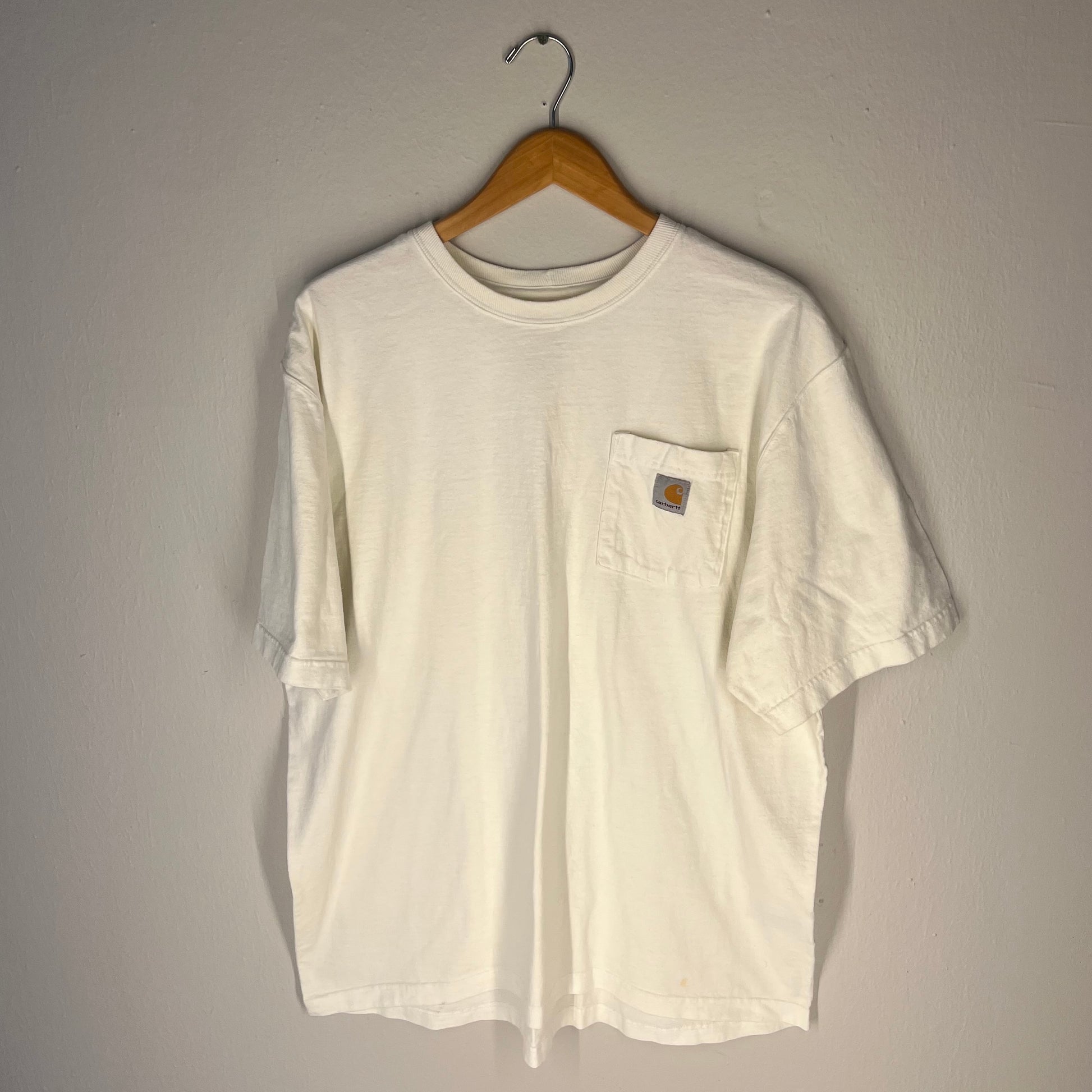 Front view of white Carhartt pocket T-shirt with logo patch on pocket
