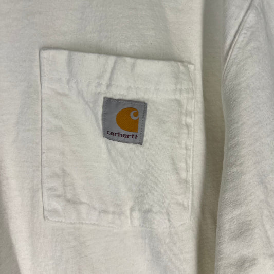 Close-up of Carhartt logo patch on pocket of white T-shirt