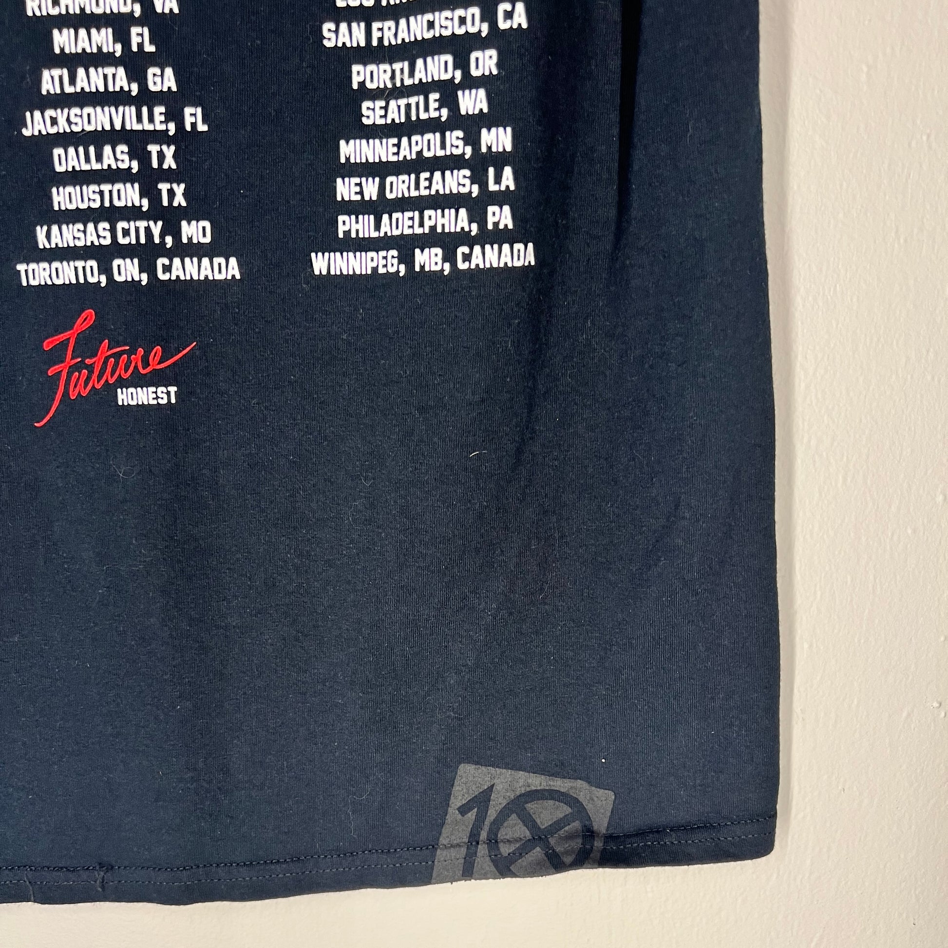 Bottom hem detail with 10.Deep crosshair logo and Future Honest signature