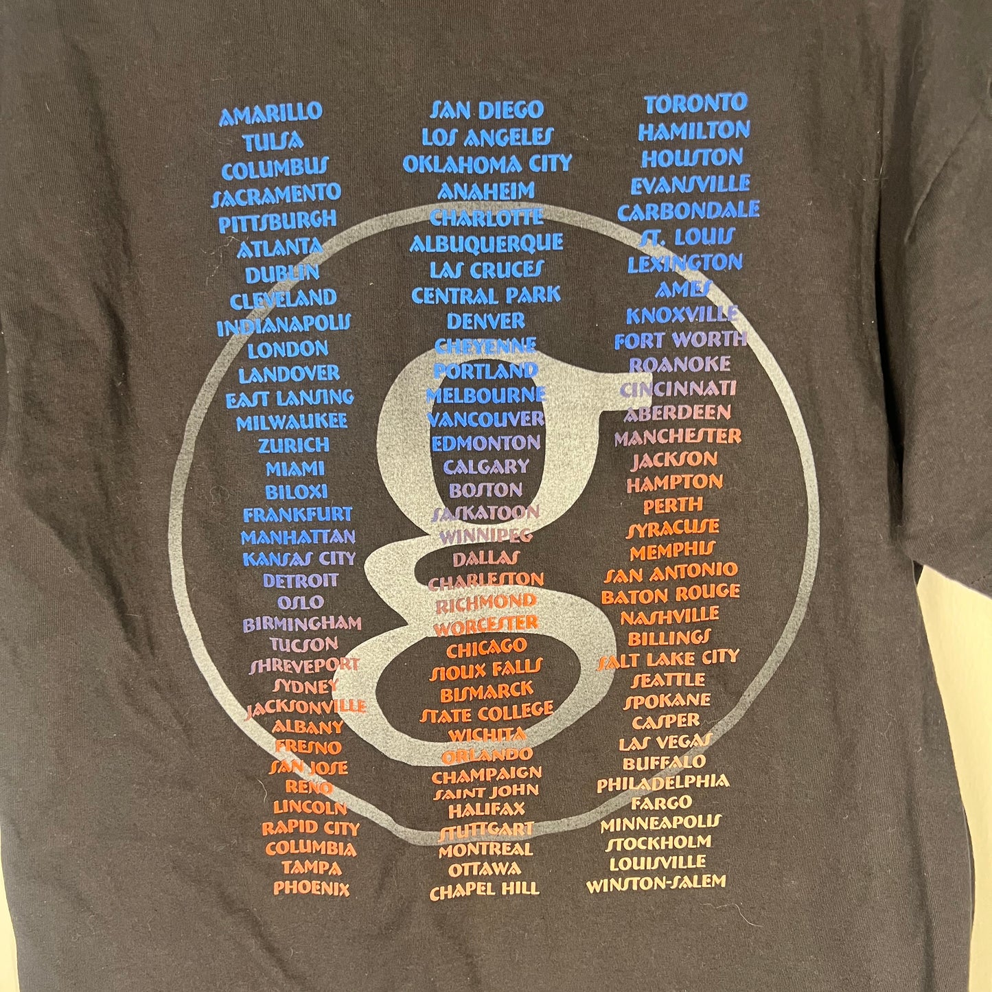 Close-up of tour city list on the back of the tee