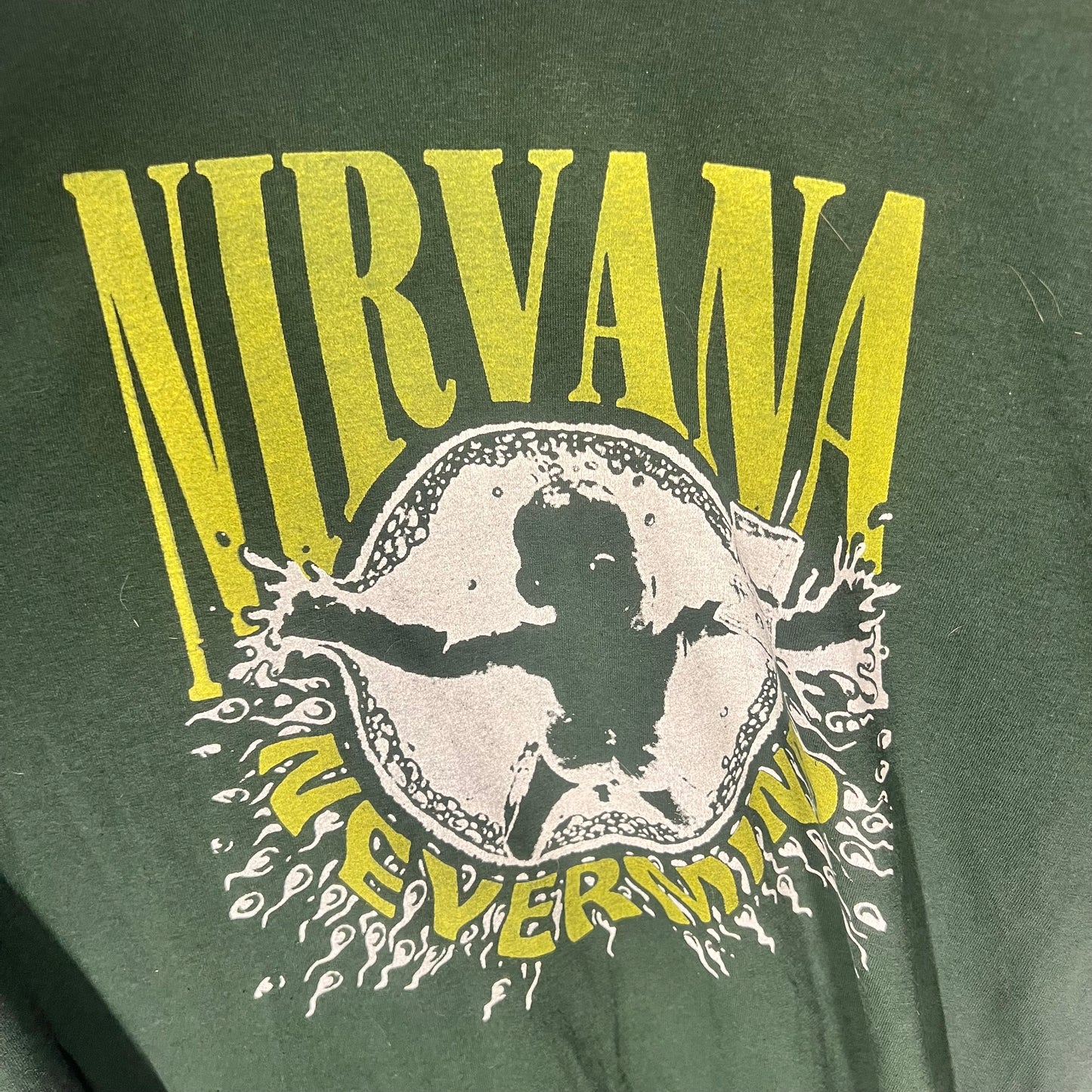 Close-up of the Nirvana Nevermind baby graphic with distressed yellow and white ink.