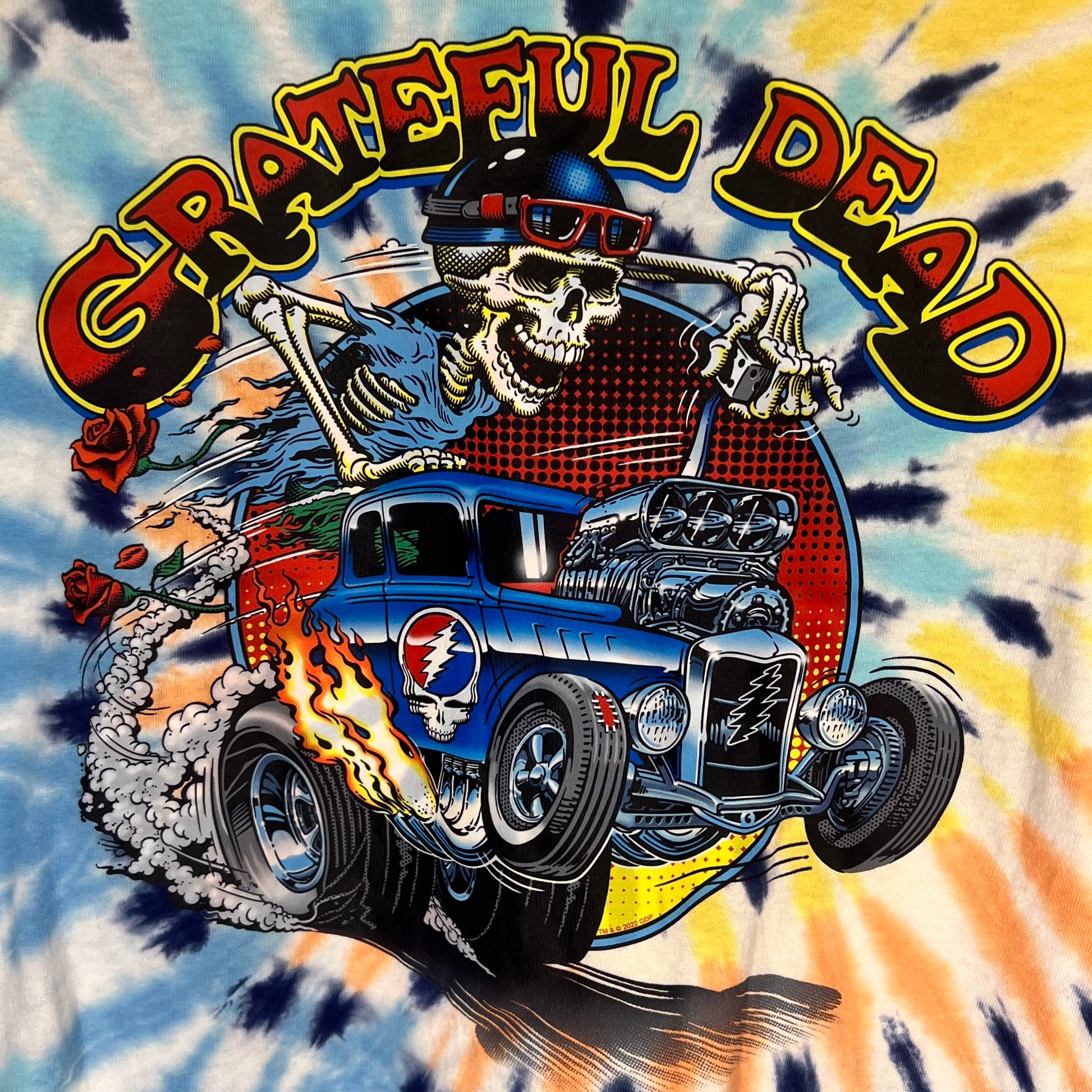 Close-up of Grateful Dead graphic featuring skeleton driving hot rod with flames