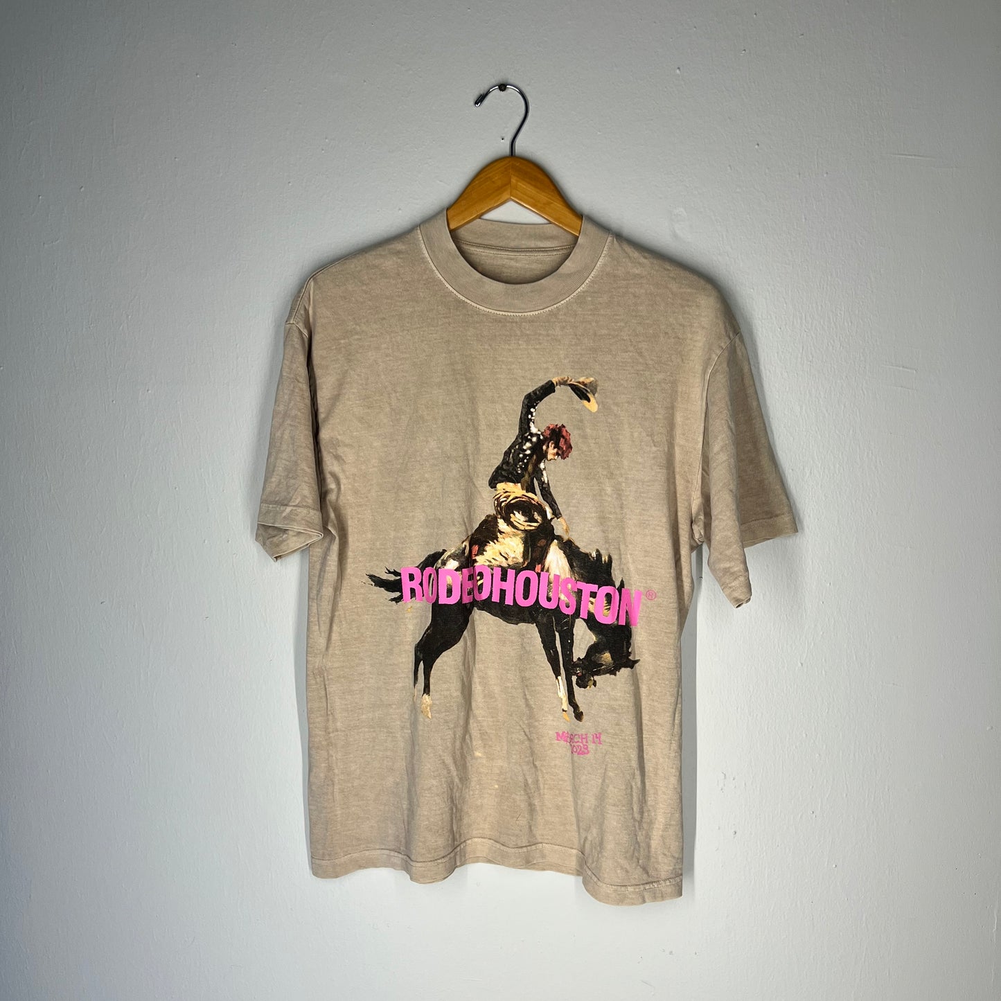 Front of MGK Rodeo Houston 2023 t-shirt with bronco rider and pink text