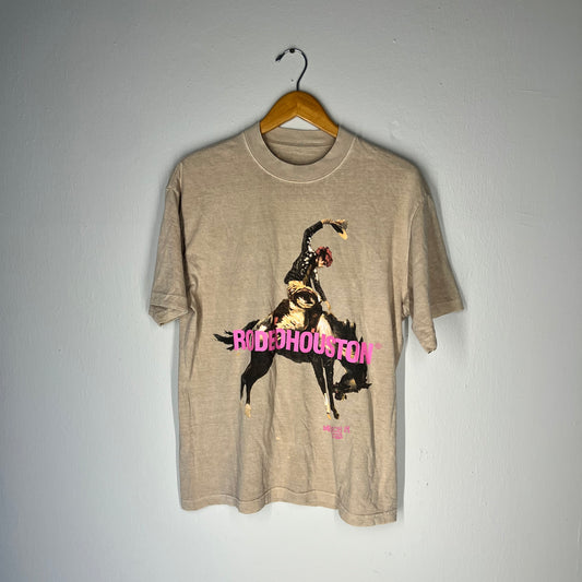 Front of MGK Rodeo Houston 2023 t-shirt with bronco rider and pink text