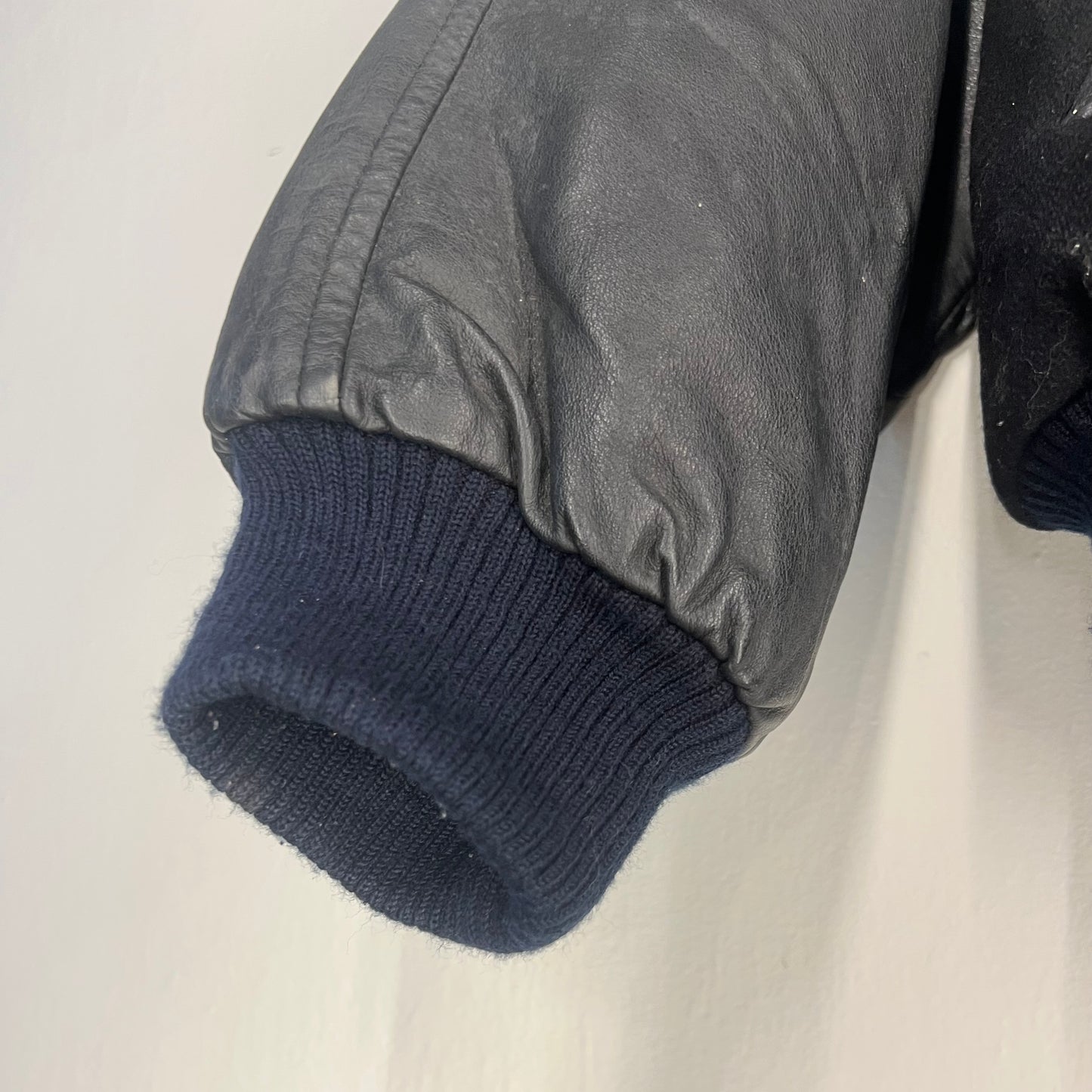 Ribbed knit cuff and leather sleeve detail