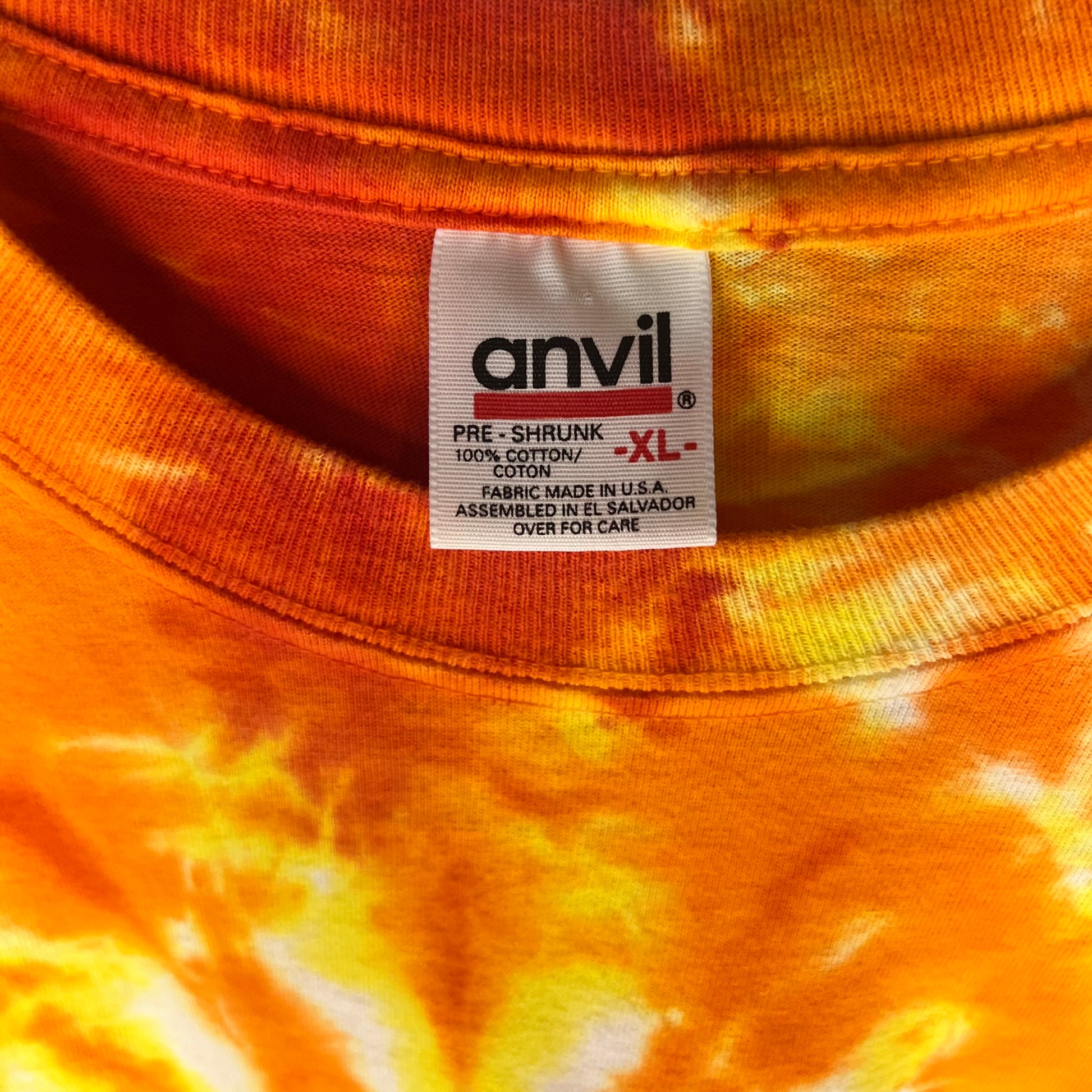 Anvil neck tag close-up reading pre-shrunk 100% cotton XL made in USA assembled in El Salvador