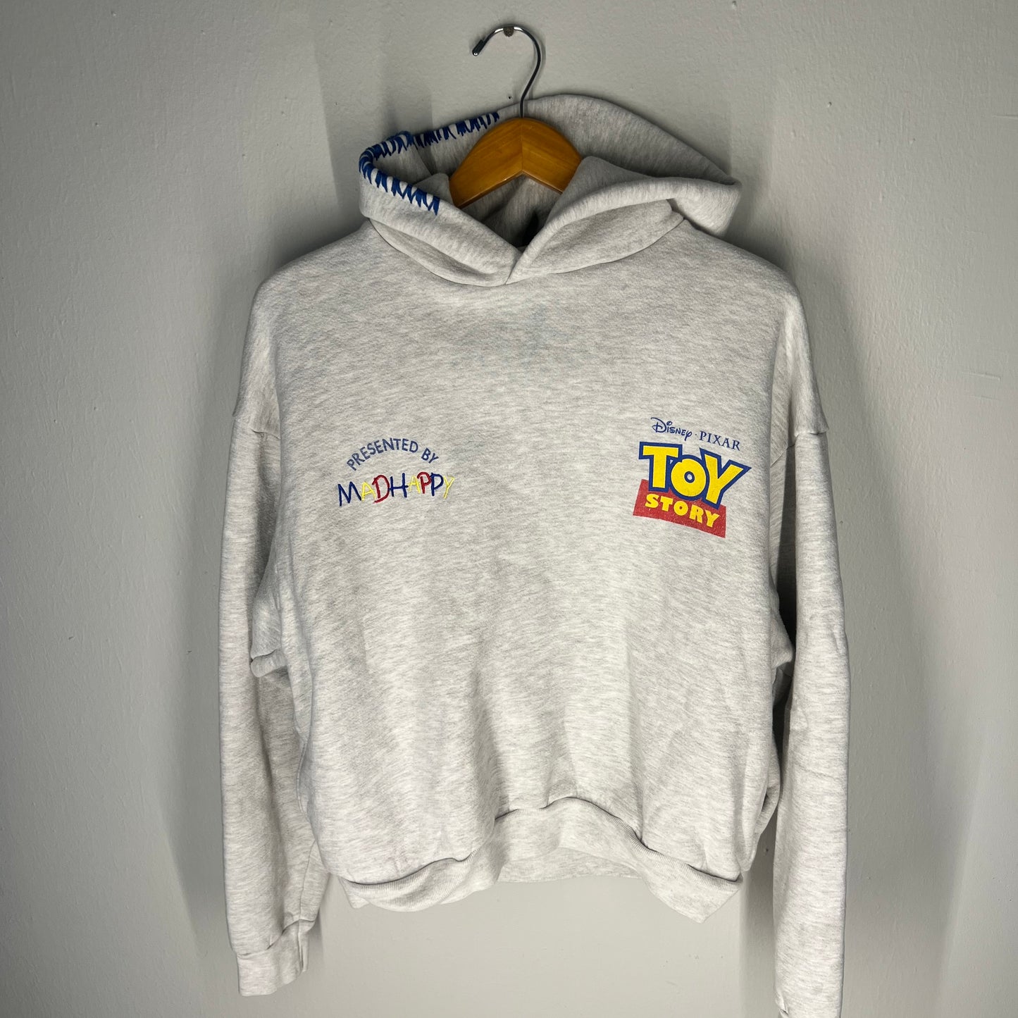 Front of grey Toy Story hoodie with Madhappy embroidery