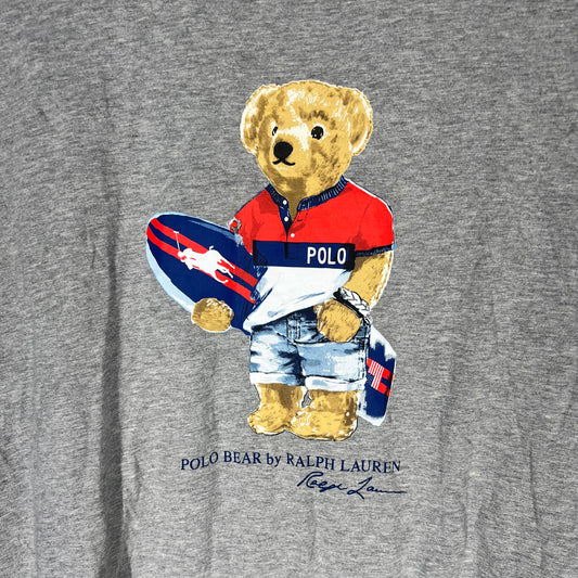 Close-up of Polo Bear in surf outfit holding surfboard