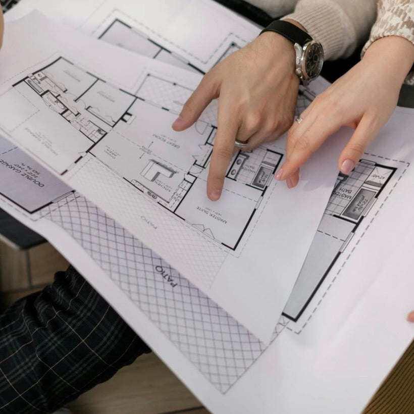 Hands reviewing residential floor plans during a renovation consultation call for home remodeling strategy by SWOProjects studio