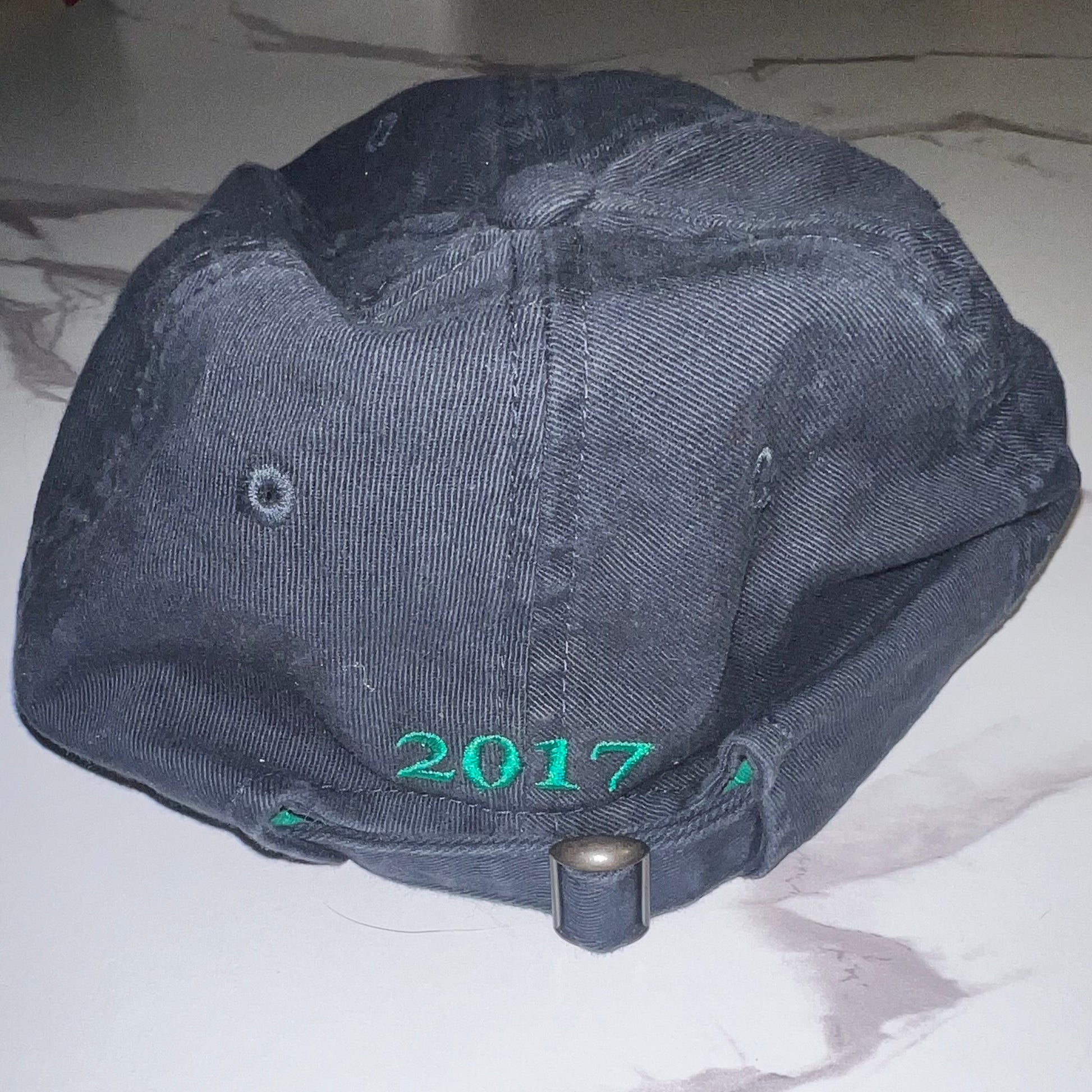 Back view with green "2017" embroidery and strapback closure