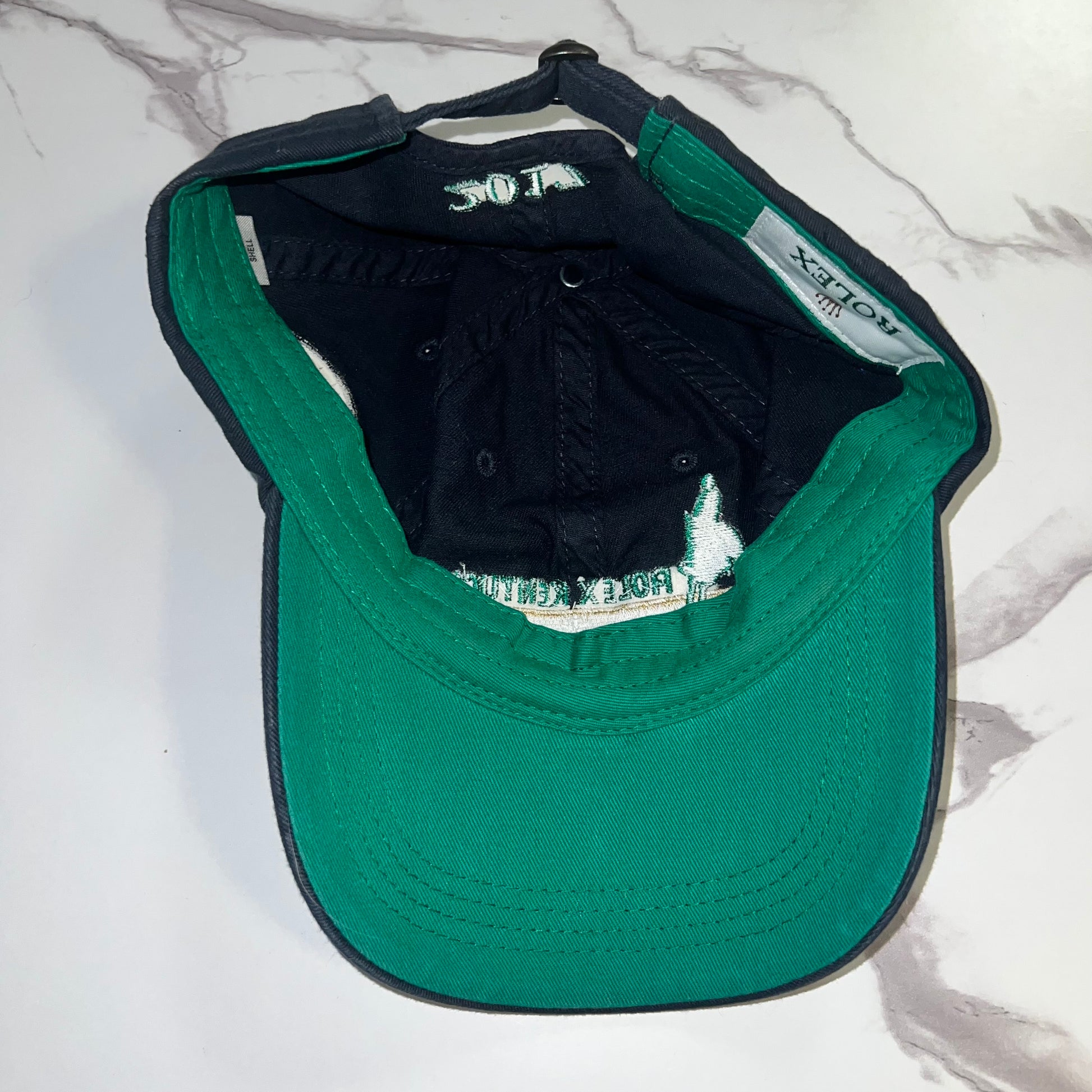Interior view of hat with green underbrim and Rolex woven tag