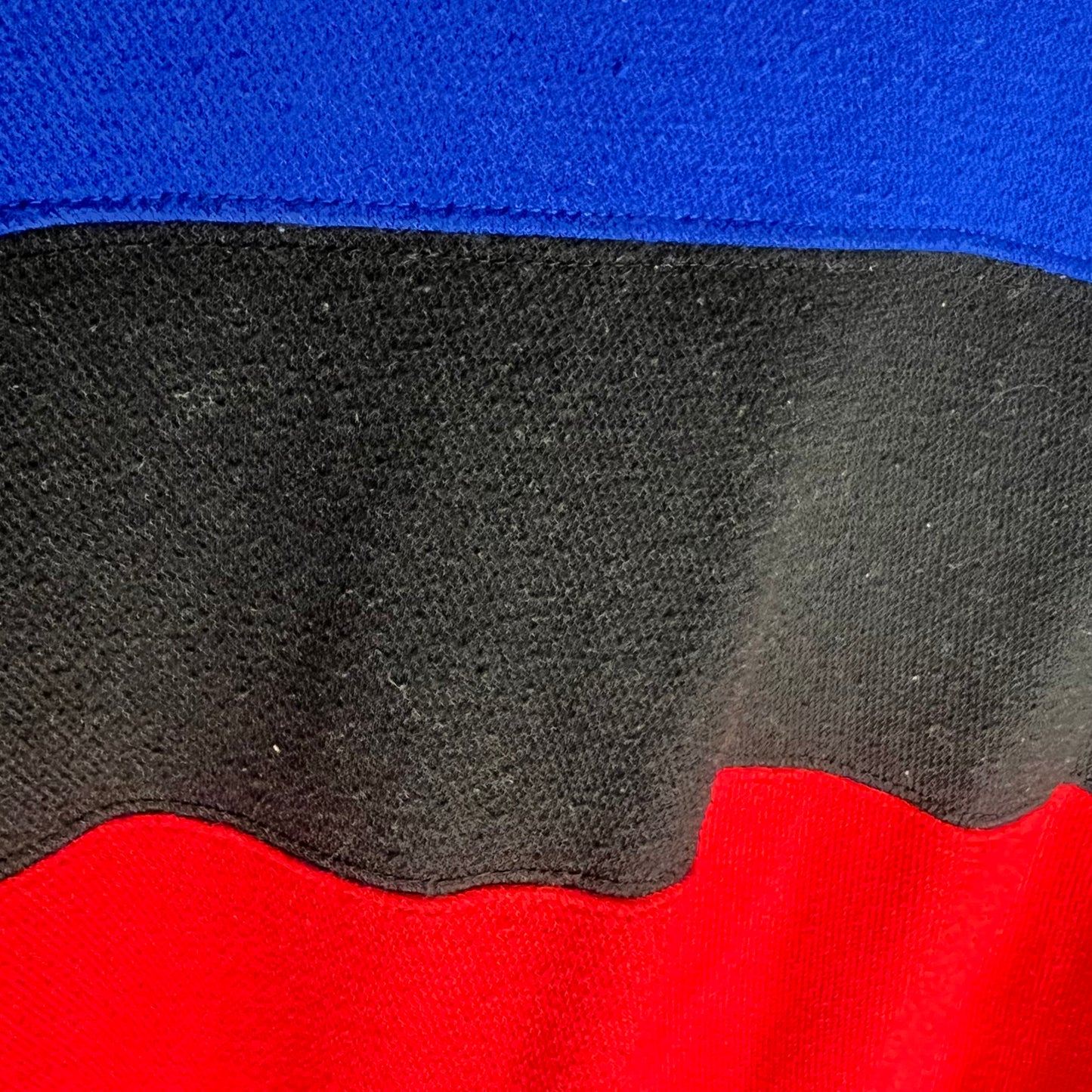 Detailed fabric texture of colorblock sections on Hilfiger t-shirt